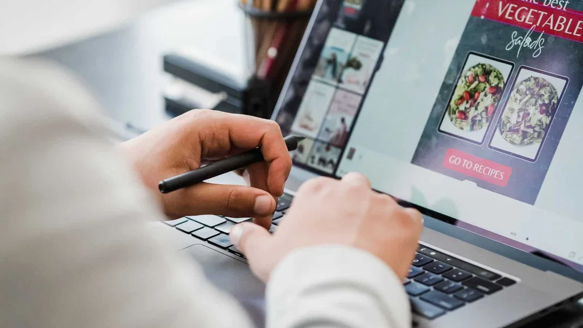 Designer creating a digital layout on a laptop