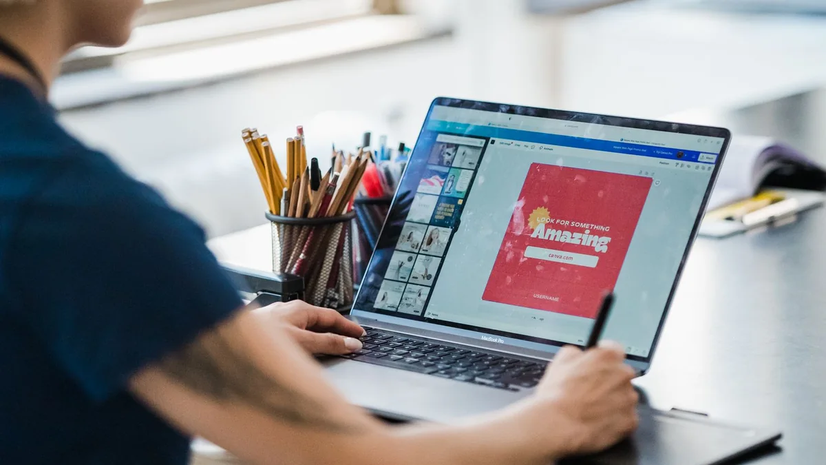 Designer reviewing a colorful layout on a laptop at a desk