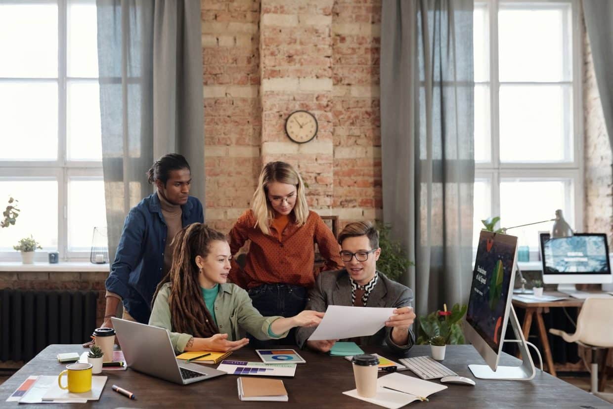 Creative professionals reviewing campaign materials in a bright studio