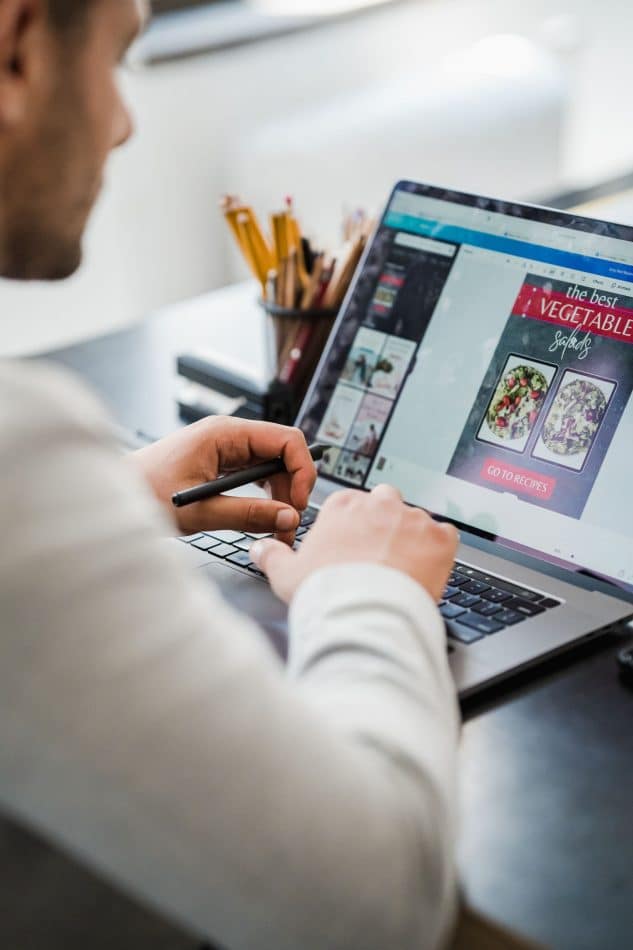 Designer creating a digital layout on a laptop