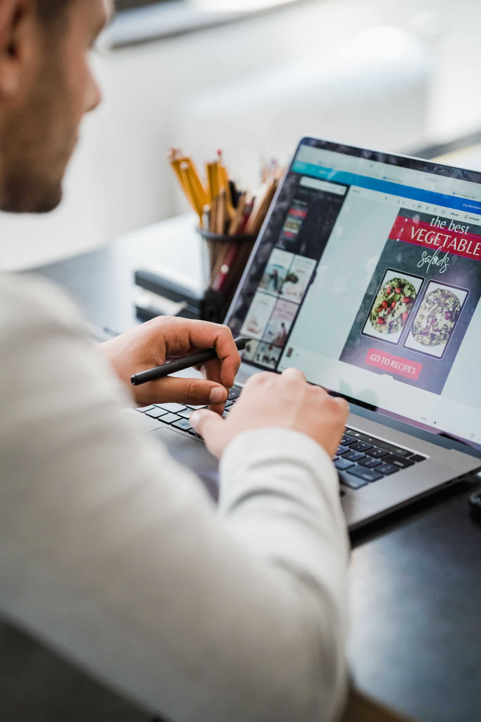 Designer creating a digital layout on a laptop