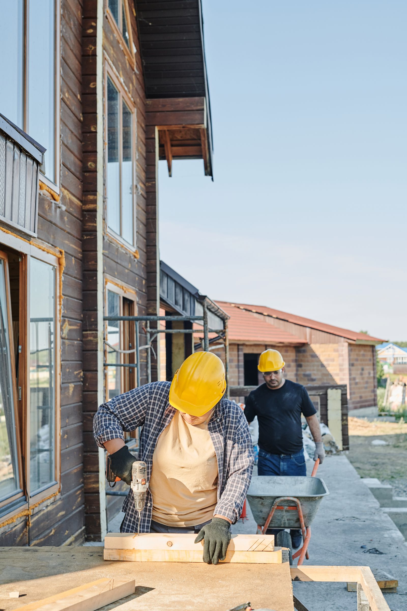 Carpenters building a wooden house — illustrative stock photo