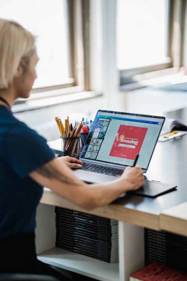 Designer reviewing a colorful layout on a laptop at a desk