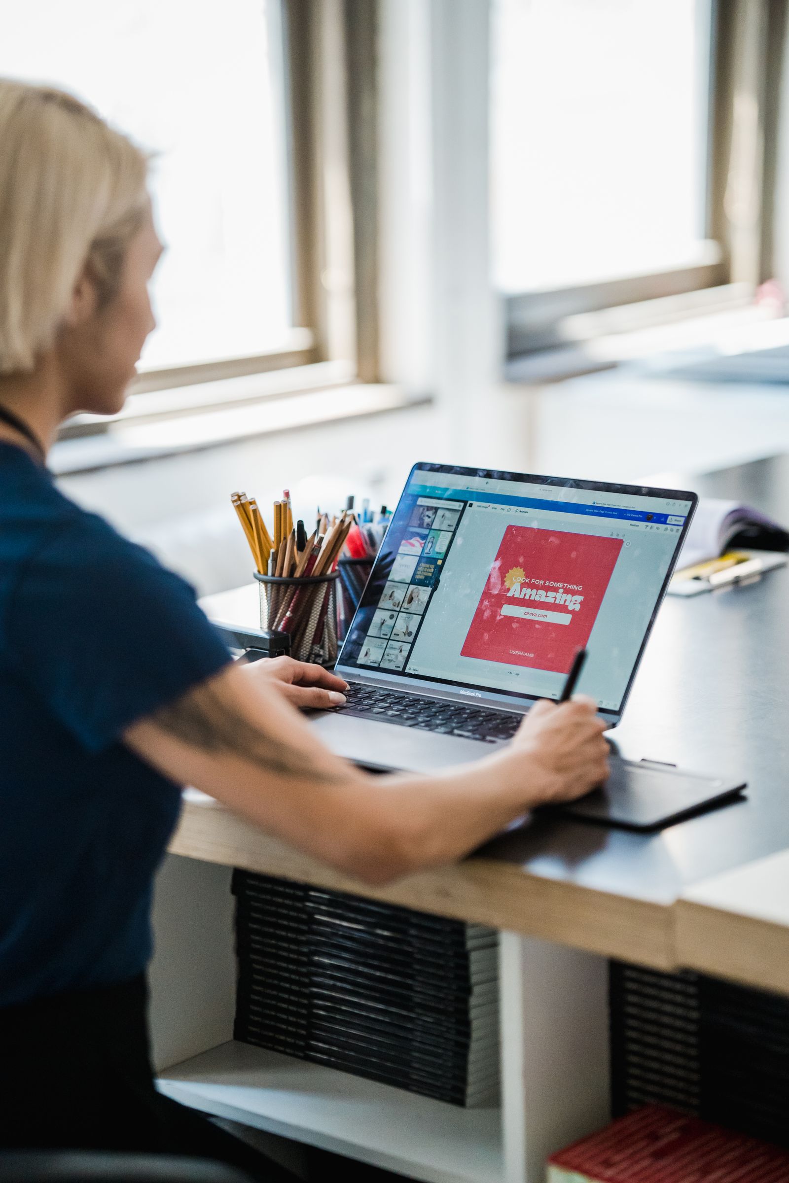 Designer reviewing a colorful layout on a laptop at a desk