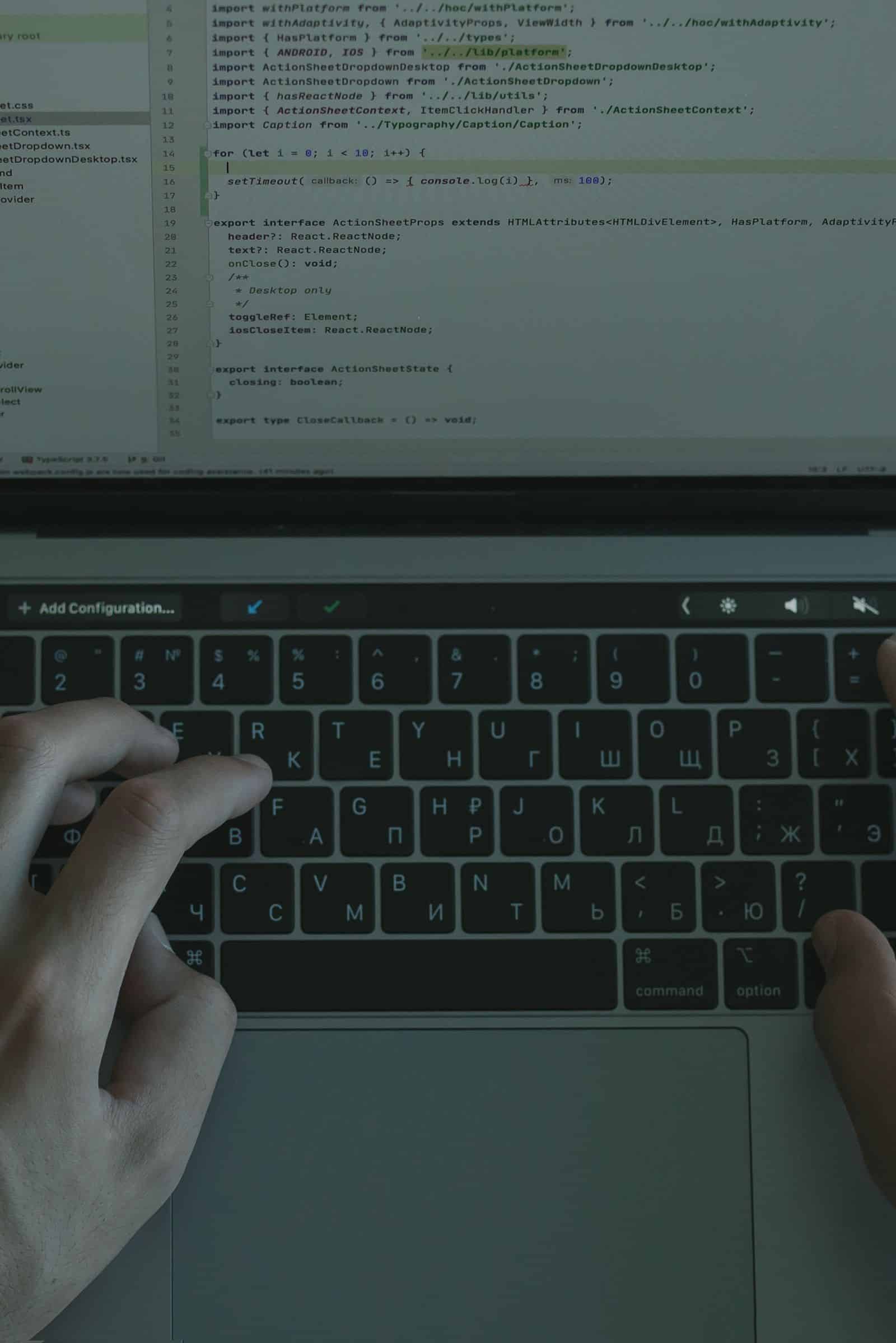 Hands working on website code on a laptop